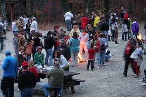 A group of people around bonfires after the Pumpkin Hike